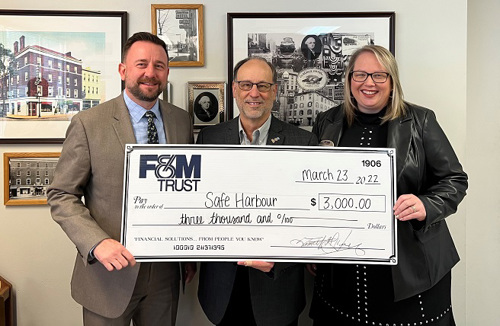 United Trust Bank representatives present a large check to Safe Harbour